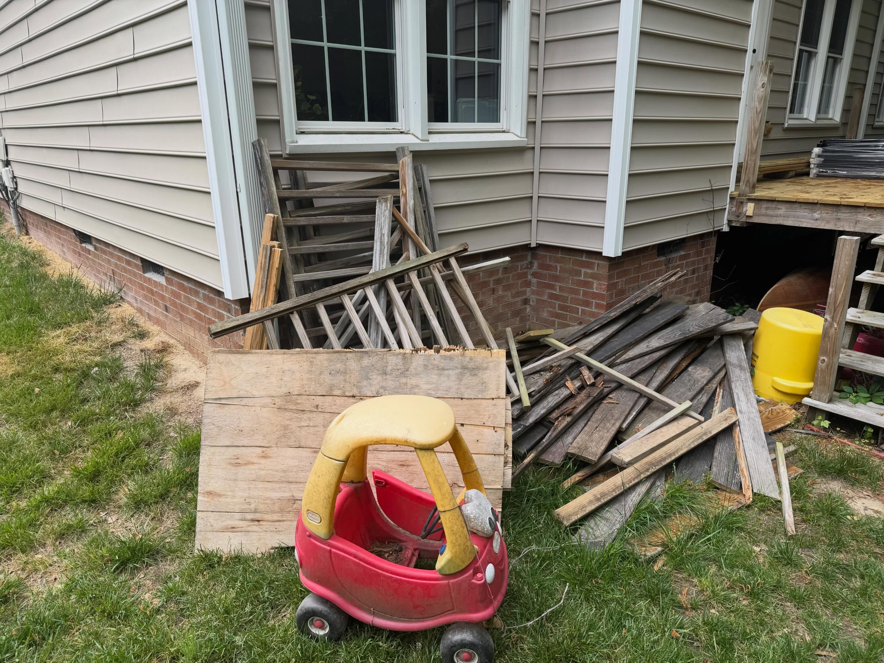 Before: discarded boards and wooden materials beside the house
