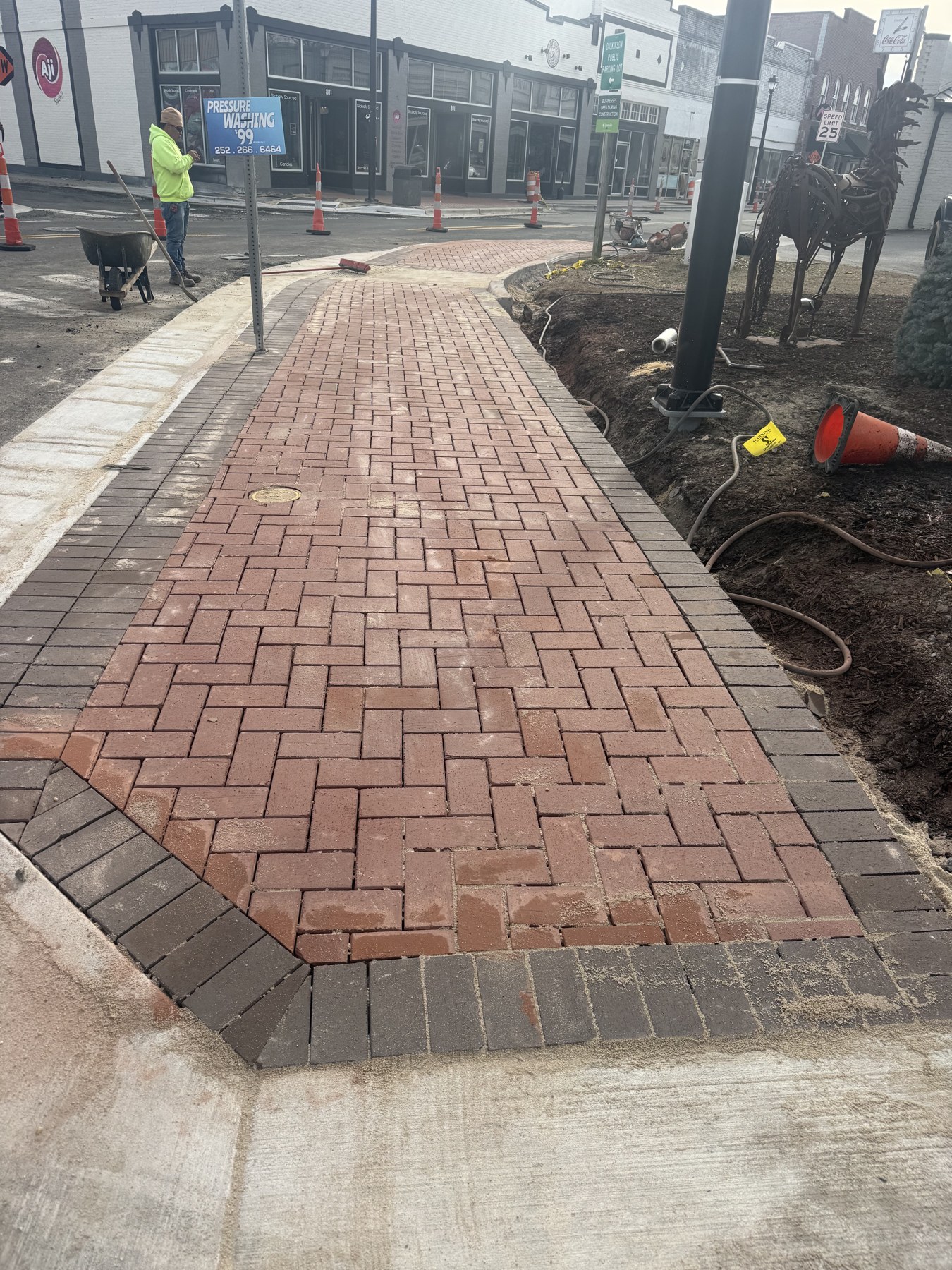Red brick sidewalk with a contrasting border beside a street