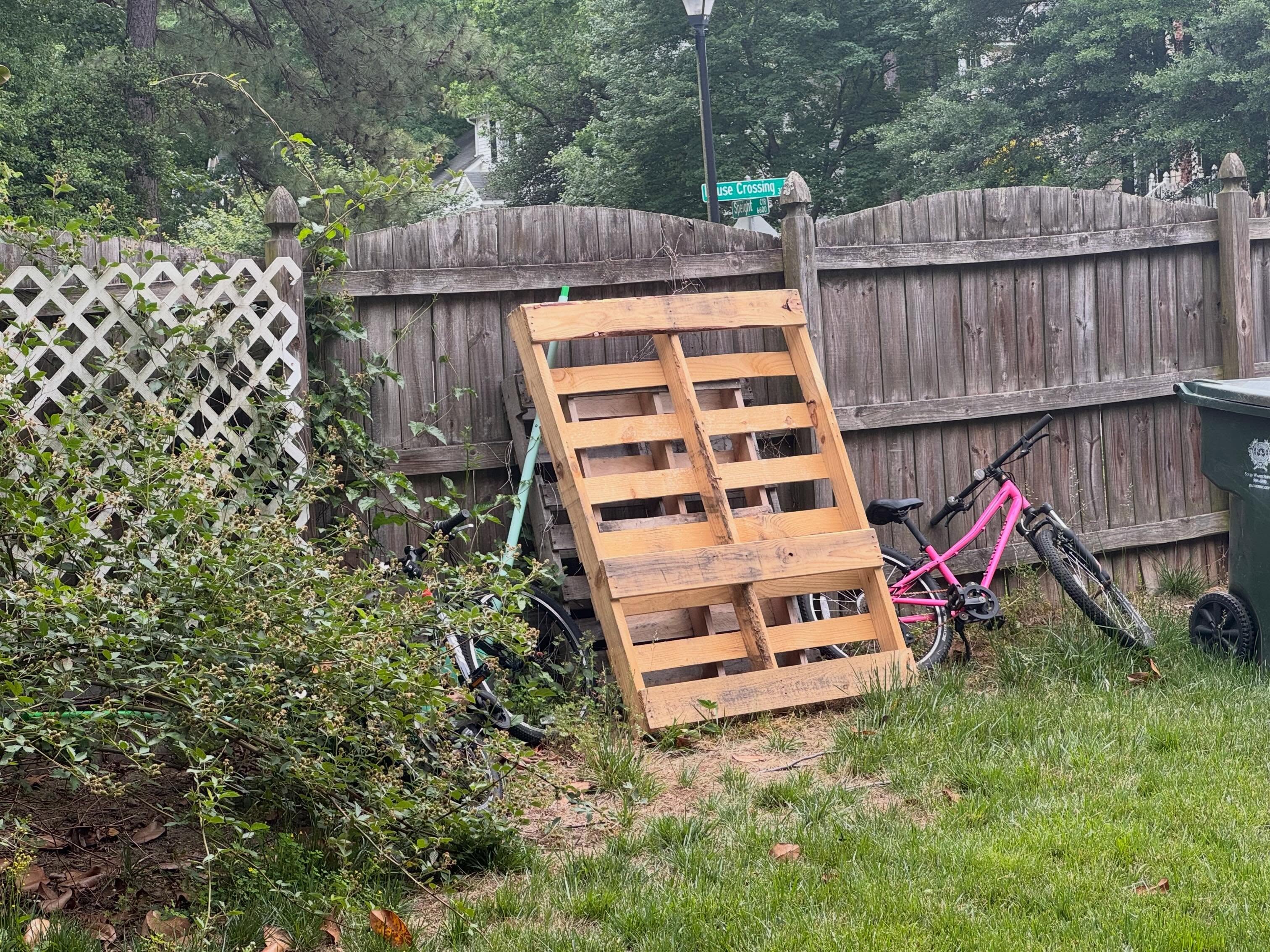 Before: wooden pallets leaning against the backyard fence
